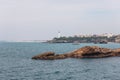 Unique rocky coastal formations repeating shape of sea waves, with lighthouse in background.ÃÂ Biarritz